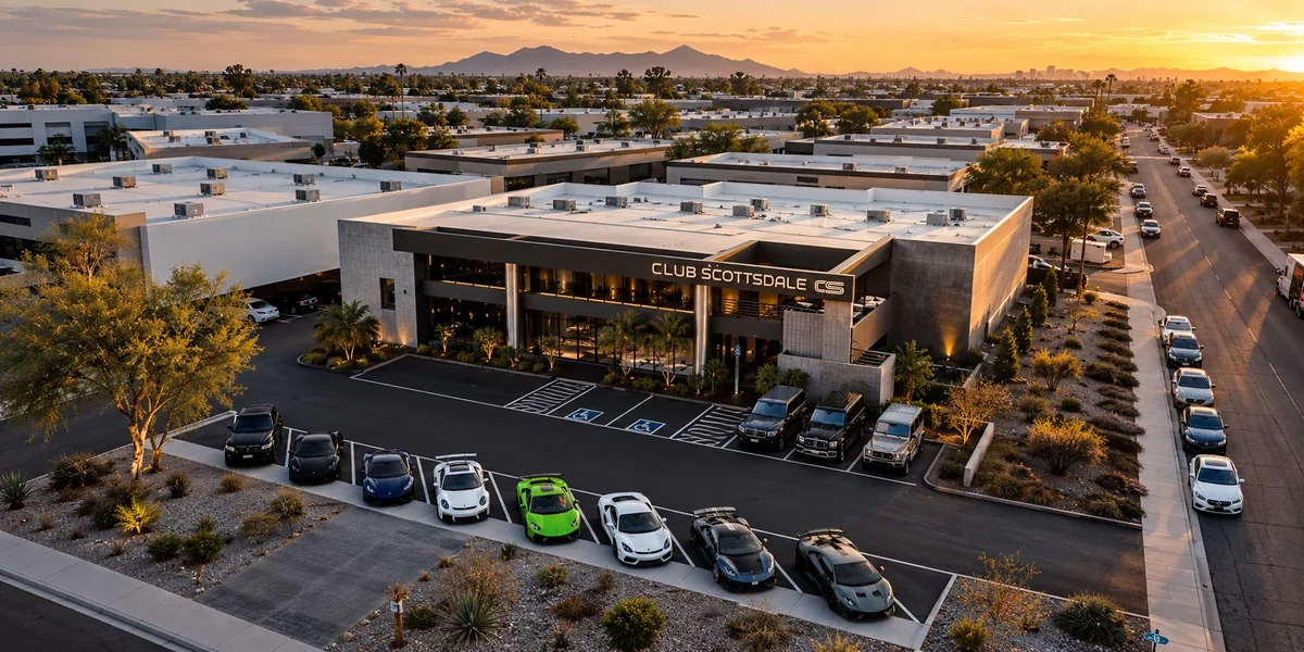 Club Scottsdale from the air at sunset: the lit facade and sign, a row of exotic cars out front, mountains on the horizon